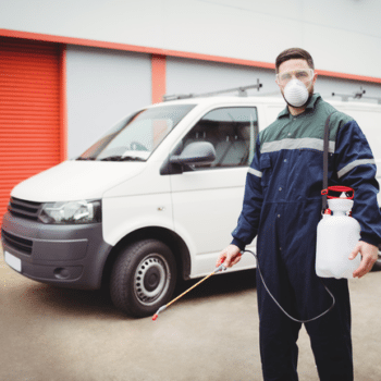 Handyman with insecticide standing in front of his van